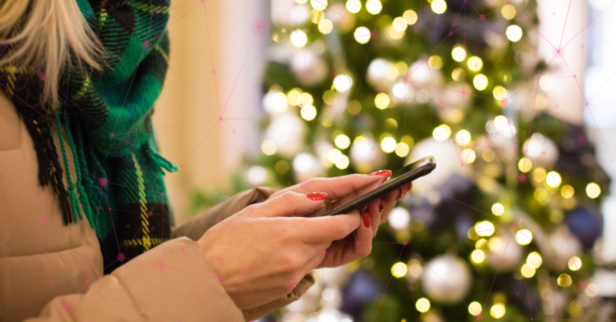 Woman holding cell phone in front of Christmas tree; Charity scam calls